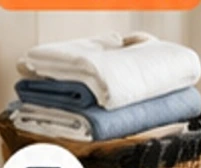 Fresh folded laundry with a delivery tote in a bright apartment